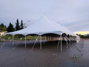 White stretch tent with arched sidewalls and peaked rooflines outdoors at dusk for a Seven Chiefs meeting setting in Morely.